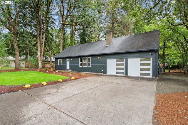 18240 SW Jay St, Beaverton, OR 97003 - view of front facade with a chimney, driveway, a front lawn, a garage, and view of scattered trees