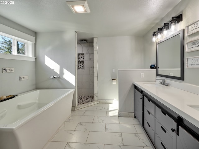 bathroom featuring a garden tub, a sink, a textured ceiling, marble finish floor, and tiled shower