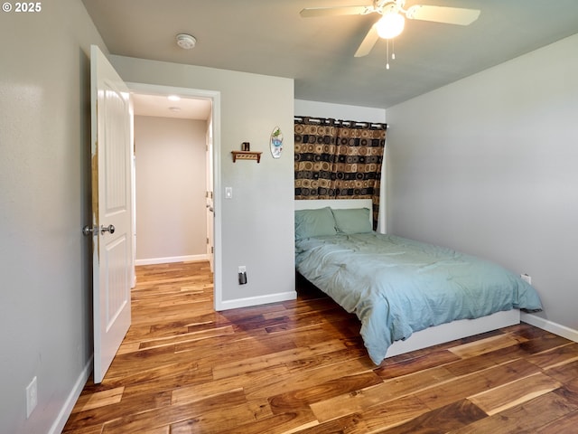 bedroom featuring baseboards, a ceiling fan, and wood finished floors