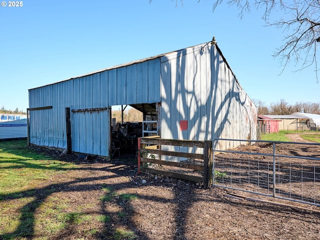 view of pole building with an exterior structure and fence