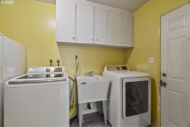 washroom featuring independent washer and dryer, sink, and cabinets