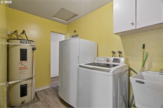 clothes washing area featuring sink, cabinets, washer / clothes dryer, strapped water heater, and light hardwood / wood-style floors