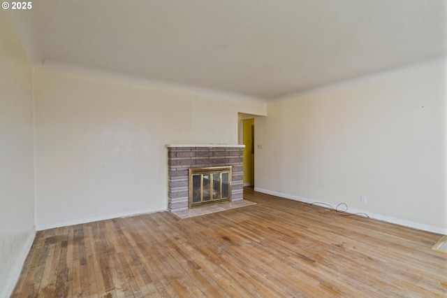 unfurnished living room with hardwood / wood-style flooring and a fireplace