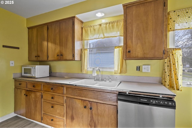 kitchen featuring sink, stainless steel dishwasher, and dark hardwood / wood-style floors