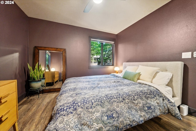 bedroom with wood finished floors, vaulted ceiling, and ceiling fan