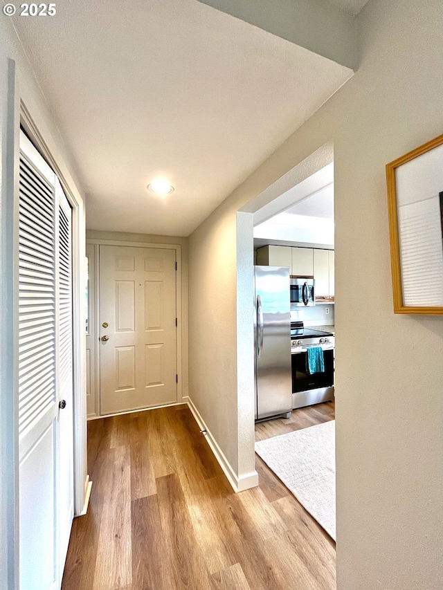 hall featuring wood finished floors and baseboards
