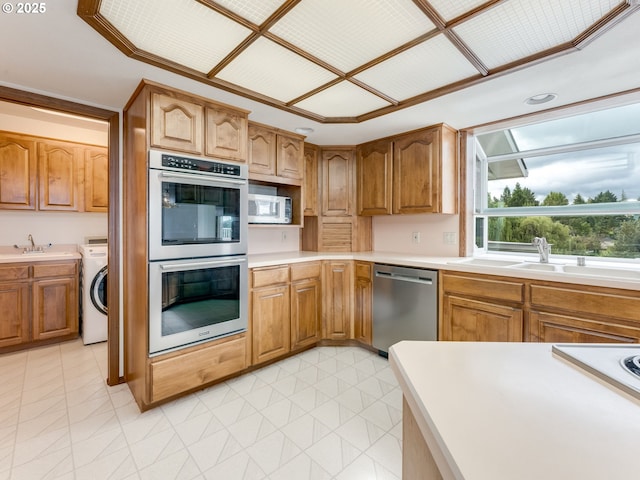 2221 NW 206th St, Ridgefield, WA 98642 - kitchen featuring appliances with stainless steel finishes, washer / clothes dryer, light countertops, and brown cabinetry