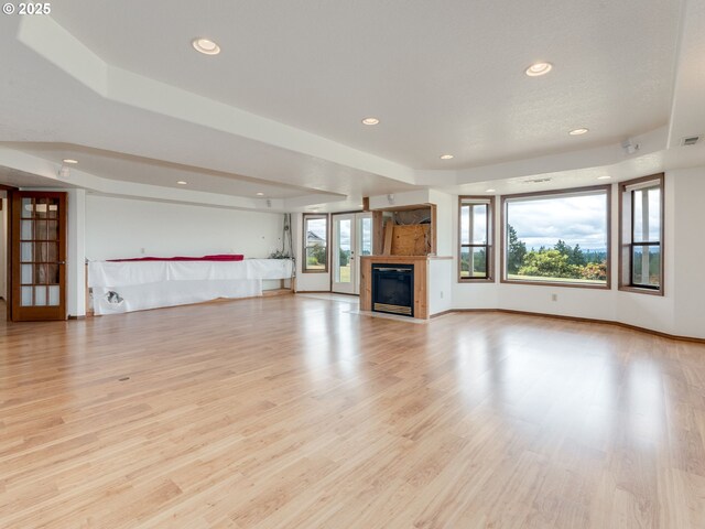 2221 NW 206th St, Ridgefield, WA 98642 - unfurnished living room with light wood-type flooring, recessed lighting, and a glass covered fireplace