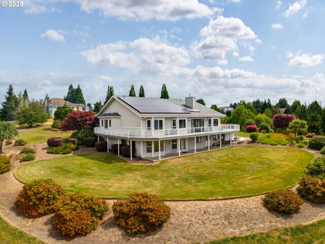 2221 NW 206th St, Ridgefield, WA 98642 - rear view of house featuring a yard, a wooden deck, a chimney, and a patio area