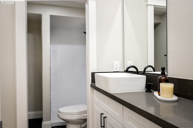 bathroom featuring toilet, vanity, and walk in shower