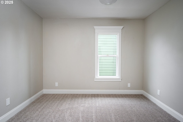 carpeted spare room featuring baseboards