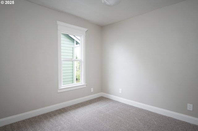 carpeted empty room featuring baseboards