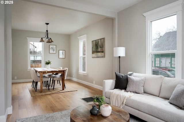 living room with light wood-type flooring, baseboards, and visible vents