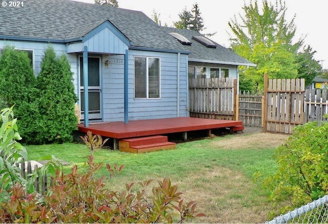 rear view of house with a yard and a deck