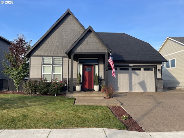 craftsman-style home with an attached garage, fence, concrete driveway, stone siding, and a front lawn