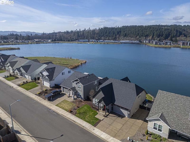 aerial view featuring a wooded view and a water view