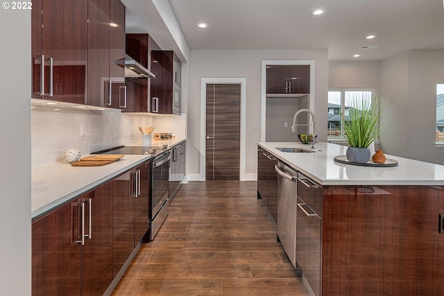 kitchen with appliances with stainless steel finishes, tasteful backsplash, dark wood-type flooring, an island with sink, and sink