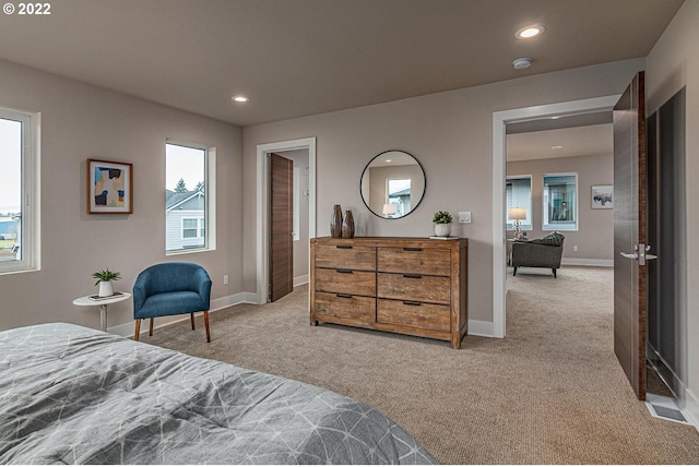 bedroom featuring light carpet and multiple windows