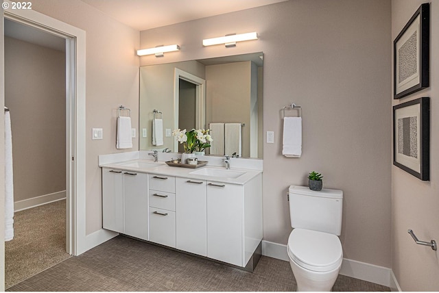 bathroom featuring double sink, toilet, and large vanity