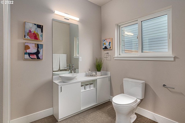 bathroom featuring vanity with extensive cabinet space and toilet