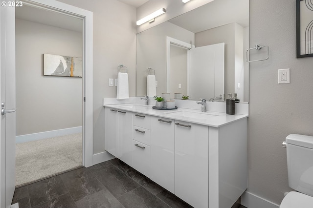 bathroom featuring tile flooring, dual sinks, toilet, and large vanity