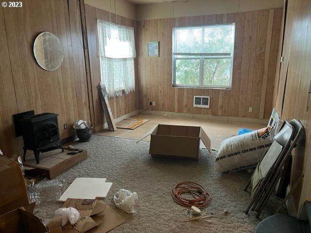 living room featuring wood walls and a wood stove