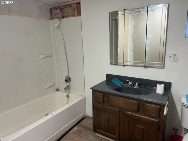 full bathroom featuring bathtub / shower combination, wood-type flooring, vanity, and toilet