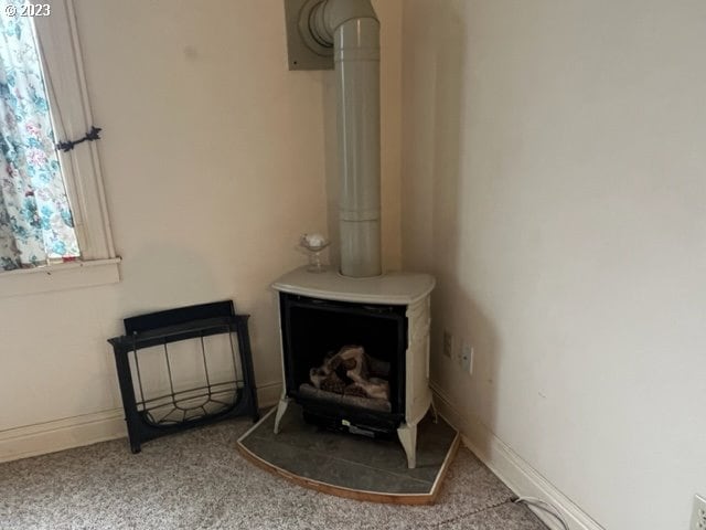 details with carpet and a wood stove