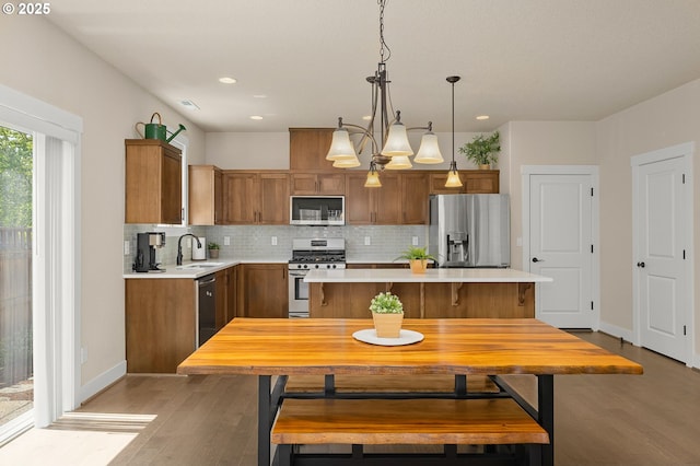 13193 SW Aubergine Ter, Sherwood, OR 97140 - kitchen with stainless steel appliances, brown cabinetry, light wood-type flooring, light countertops, and recessed lighting