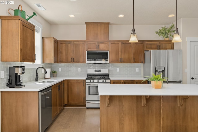 13193 SW Aubergine Ter, Sherwood, OR 97140 - kitchen with stainless steel appliances, brown cabinets, light countertops, tasteful backsplash, and recessed lighting