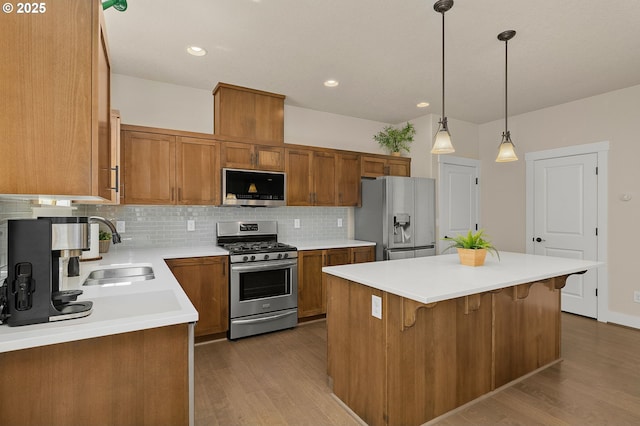 13193 SW Aubergine Ter, Sherwood, OR 97140 - kitchen featuring stainless steel appliances, brown cabinetry, dark wood-style floors, decorative backsplash, and recessed lighting