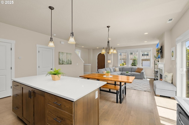 13193 SW Aubergine Ter, Sherwood, OR 97140 - kitchen featuring arched walkways, light wood finished floors, open floor plan, light countertops, and recessed lighting