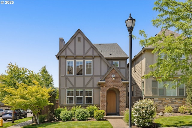 13193 SW Aubergine Ter, Sherwood, OR 97140 - tudor house featuring stucco siding, brick siding, roof with shingles, and a chimney