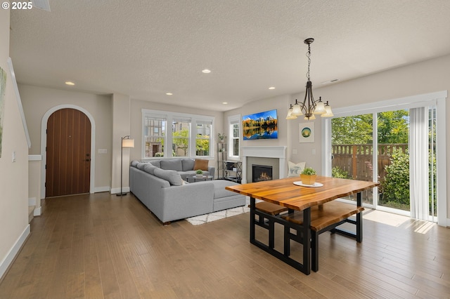 13193 SW Aubergine Ter, Sherwood, OR 97140 - dining space featuring a lit fireplace, plenty of natural light, a textured ceiling, arched walkways, and recessed lighting