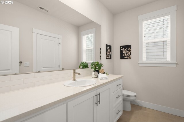bathroom with toilet, baseboards, visible vents, and vanity