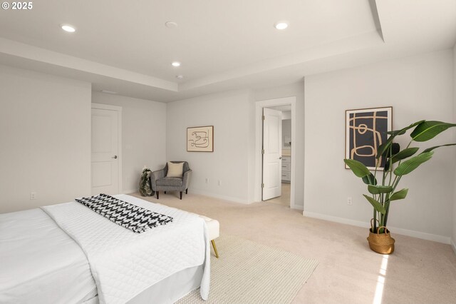 bedroom featuring recessed lighting, a tray ceiling, light colored carpet, and baseboards