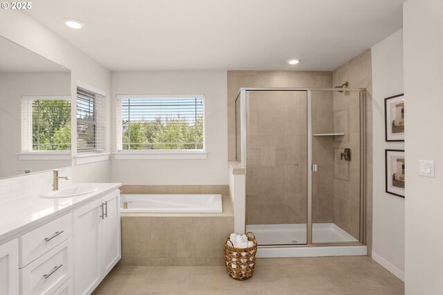 full bath featuring tile patterned floors, a shower stall, a bath, and vanity