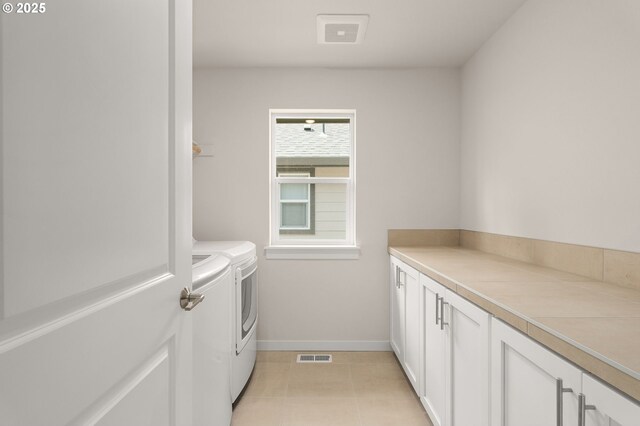 washroom featuring visible vents, baseboards, cabinet space, independent washer and dryer, and light tile patterned floors