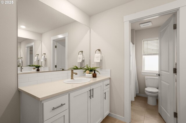 full bath with tile patterned floors, baseboards, vanity, and toilet