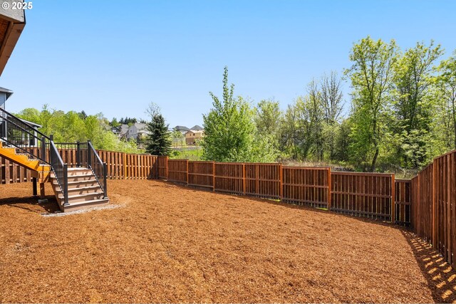 view of yard featuring a fenced backyard and stairs