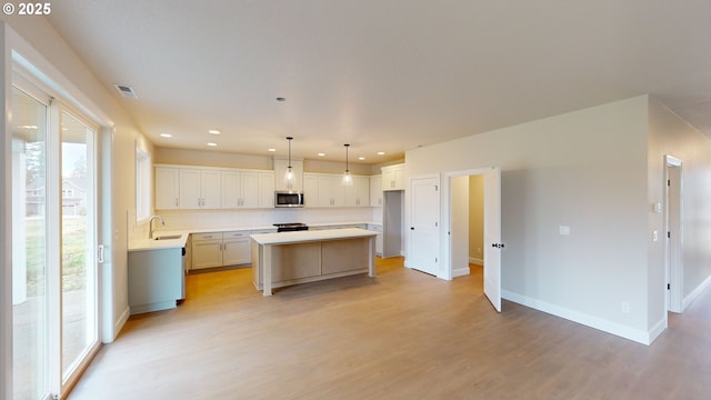 kitchen with pendant lighting, white cabinetry, sink, decorative backsplash, and a center island