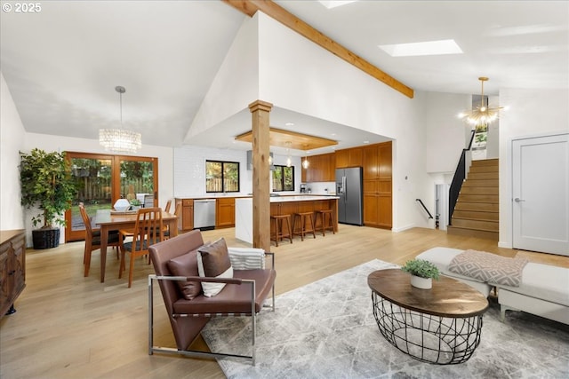 3520 Red Cedar Way, Lake Oswego, OR 97035 - living room with a chandelier, stairs, light wood-style floors, high vaulted ceiling, and a skylight