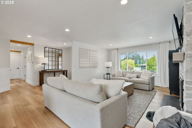 living room with light wood-style floors, recessed lighting, baseboards, and a fireplace