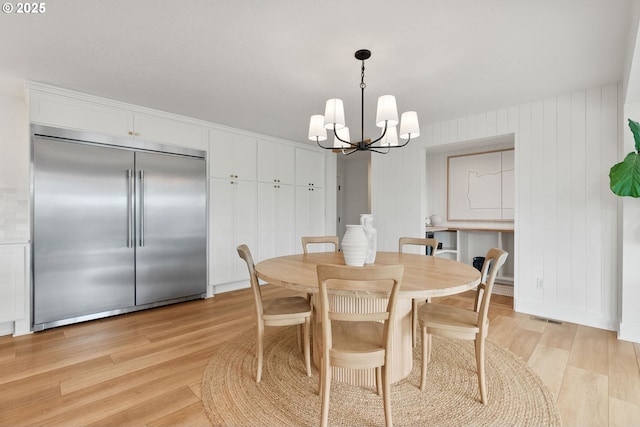dining room with visible vents, a notable chandelier, and light wood finished floors