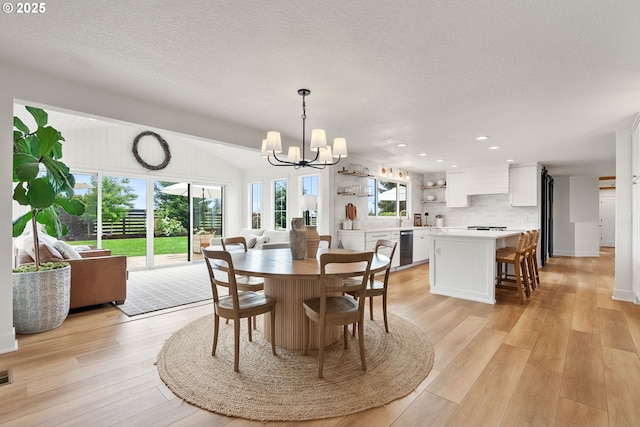 dining room featuring plenty of natural light, recessed lighting, light wood-style flooring, and a notable chandelier