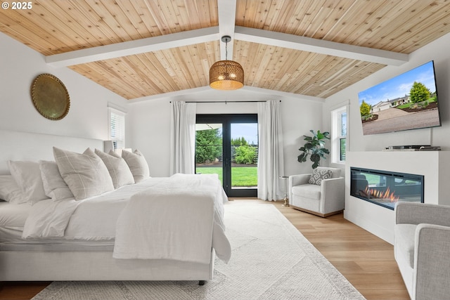 bedroom featuring a glass covered fireplace, wooden ceiling, lofted ceiling with beams, and wood finished floors