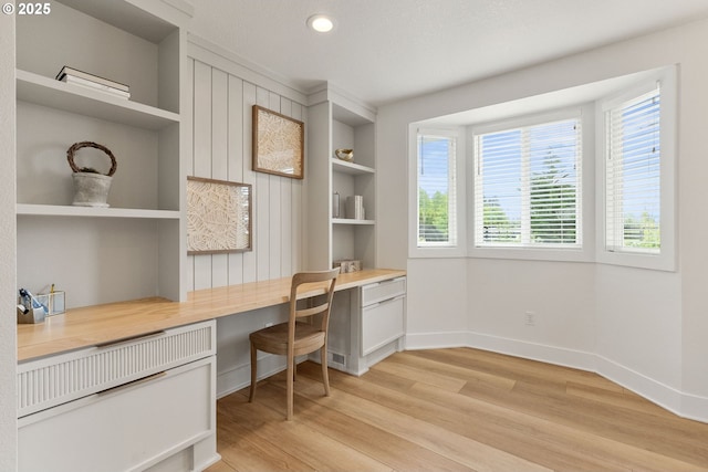 office space with recessed lighting, baseboards, built in study area, and light wood-type flooring