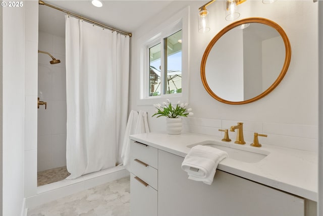 bathroom featuring vanity, a tile shower, and marble finish floor
