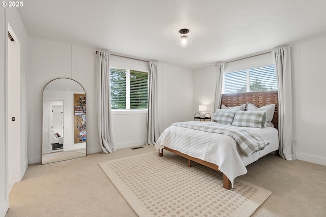 bedroom with light carpet and a textured ceiling