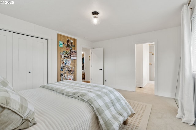 bedroom with a closet, baseboards, and light carpet